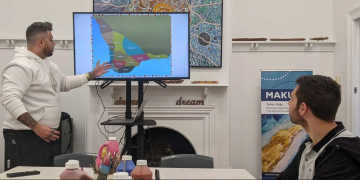 Man presenting a picture of a map on a screen.