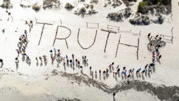 Truth inscribed in soft sand on a serene beach, capturing a fleeting moment of clarity by the ocean's edge.