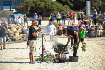 A man grilling on the beach, enjoying a sunny day by the ocean.
