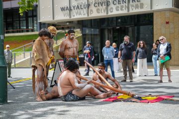 A group sits together on the ground, fostering community and connection.